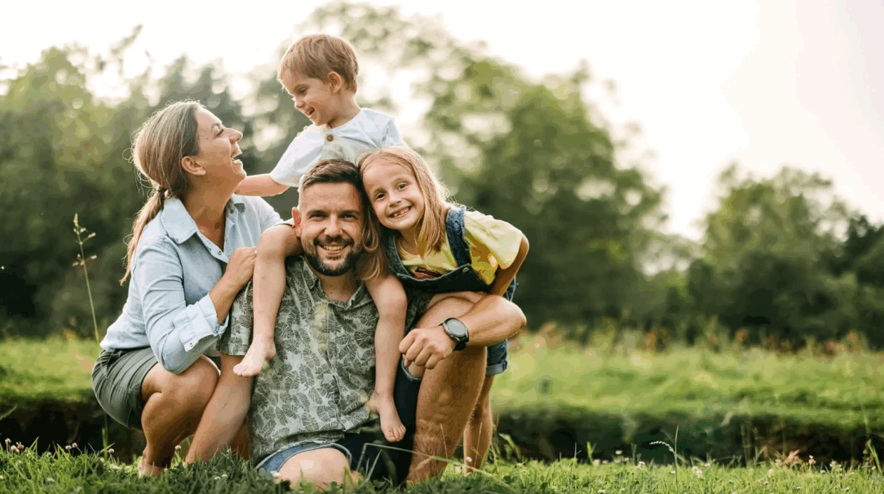 Familia se abraza en un prado verde con vínculos cercanos