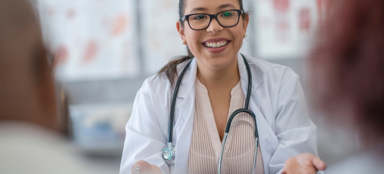 Atención médica como obtener la tarjeta sanitaria en España doctora sonriente recibe a un paciente migrante con tarjeta sanitaria en España