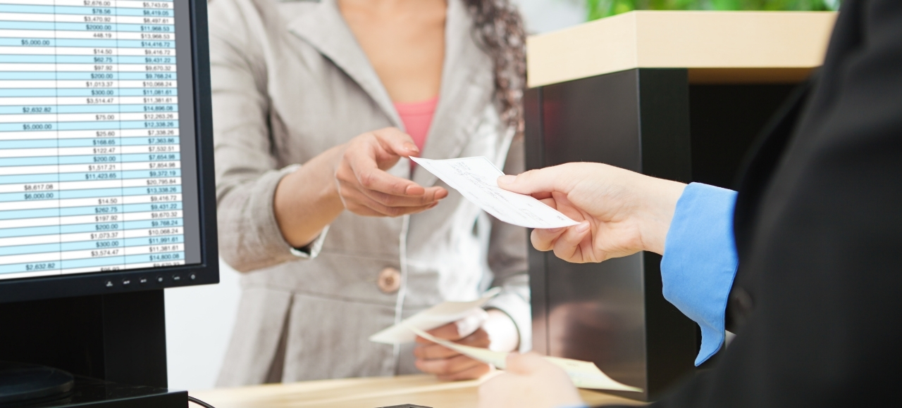 Cuenta bancaria como extranjero residente en España Una persona cobra un cheque en una entidad bancaria. Explicamos cómo abrir una cuenta como extranjero sin NIE