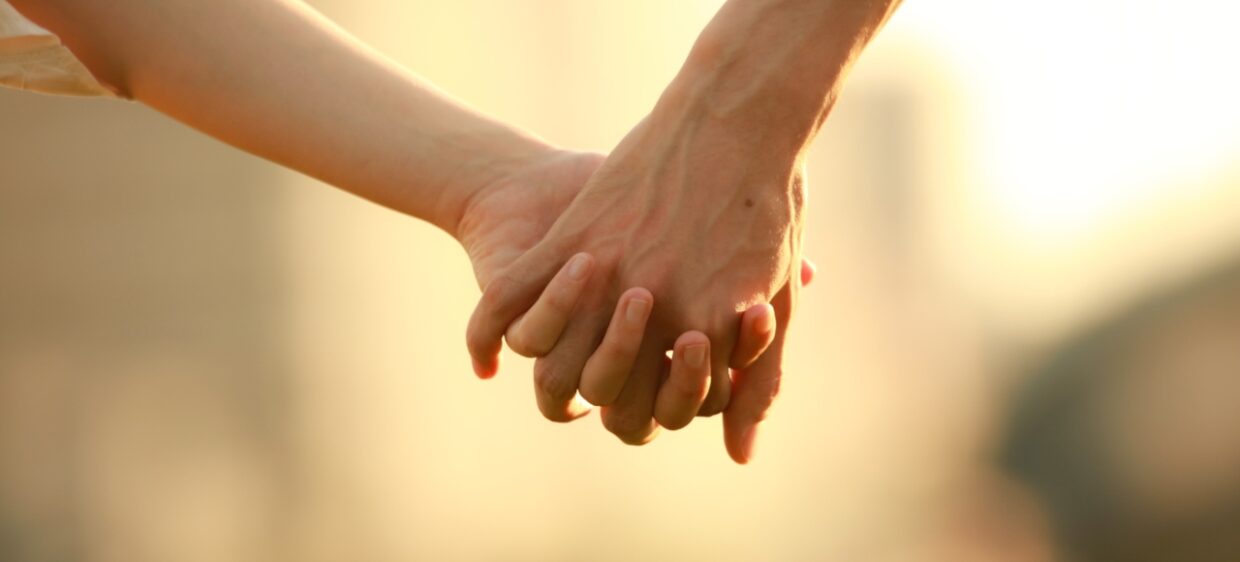 Dos manos entrelazadas de una pareja de hecho en España
