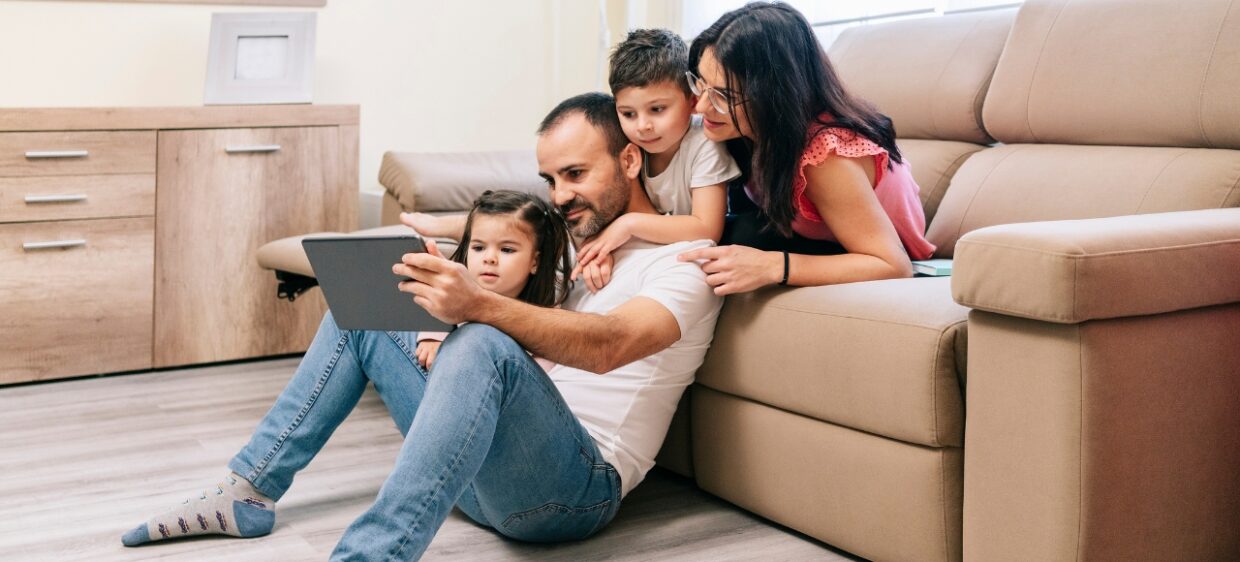 Una familia mira la guía publicada en Protección Familiar del Migrante, con respuestas de Santalucía en alianza con la app Venezuela Virtual.